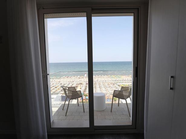 Vista sul mare da una stanza con balcone e due sedie.