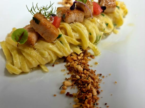 Tagliatelle con cubetti di salmone e granella croccante.